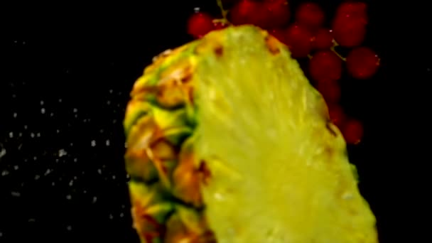 Saftig ananas och röda vinbär tappade i vattnet — Stockvideo