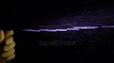 Püskürtme kullanarak eldiven bir erkekte şişe ve Temizleme 