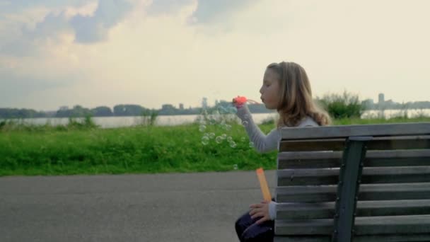 Cute curly girl is playing with soap Bubbles — Stock Video