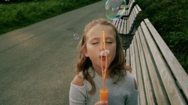 Sevimli kıvırcık kız sabun köpüğü ile oynuyor 