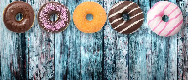 Diverse donuts på trä bakgrund — Stockfoto