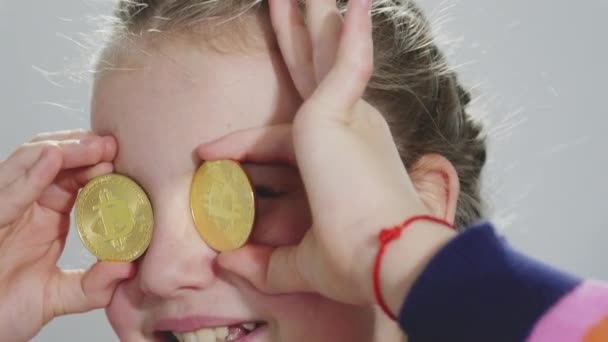 Χαριτωμένο Κορίτσι Κρατώντας Μια Χρυσή Bitcoin Στο Χέρι Κοιτάζοντας Την — Αρχείο Βίντεο