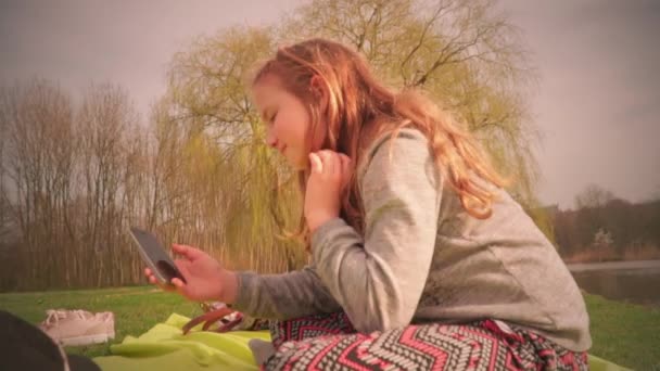 Menina Adolescente Bonito Sentado Grama Parque Segurando Smartphone — Vídeo de Stock