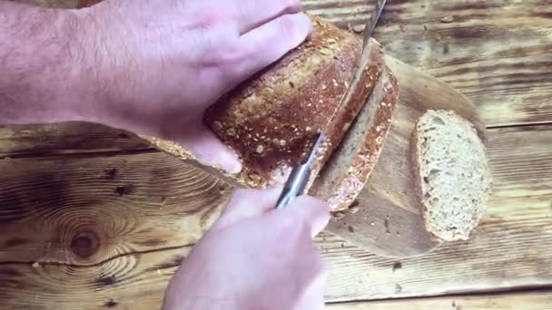 Nahsicht Mann Schneidet Brot Auf Holzschneidebrett Scheiben — Stockvideo