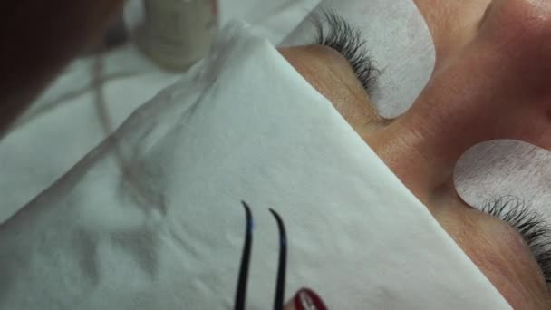 Limma Konstgjorda Ögonfransar Med Pincett Kosmetisk Procedur Ögonfransförlängning Kvinna Öga — Stockvideo