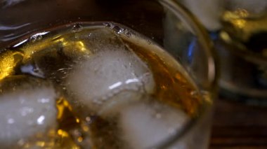 Buz küpleri bir bardak viskinin içinde erir. 
