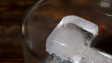 Buz küpleri bir bardak viskinin içinde erir. 