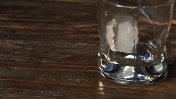 金麦芽威士忌倒入一个装有冰块的杯子里 — 图库视频影像