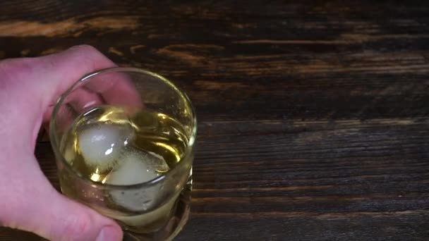 Mano Che Tiene Bicchiere Whisky Con Cubetti Ghiaccio Sullo Sfondo — Video Stock