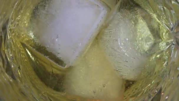 Widok Góry Obracającą Się Szklankę Złotą Whisky Kostką Lodu — Wideo stockowe