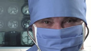 Koruyucu tıbbi maskeli, gülümseyen pozitif doktorun portresi, tamam işareti gösteriyor.