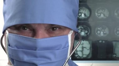 Koruyucu tıbbi maskeli, gülümseyen pozitif doktorun portresi, tamam işareti gösteriyor.