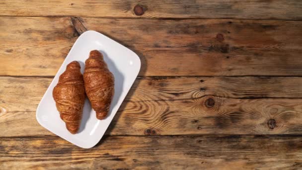 フランスのクロワッサンを食べる動きを停止します それはプレートに表示され 誰かがそれを食べる 現代の健康的な朝食 — ストック動画