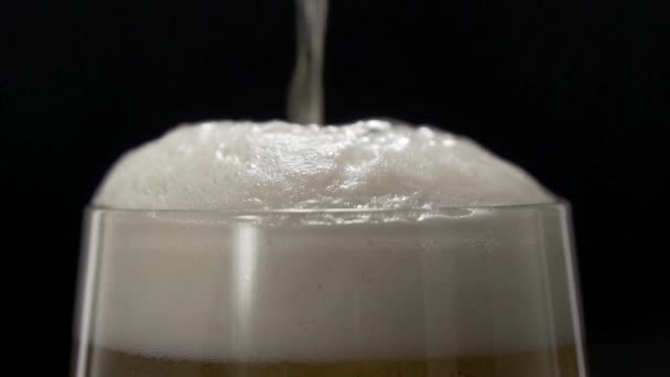 啤酒倒入装有白色泡沫的杯子中 啤酒在玻璃杯中沉淀 — 图库视频影像