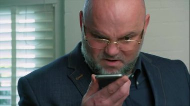  Sinirli, duygusal bir adam, engelliye bağırıyor ve akıllı telefondan konuşuyor.