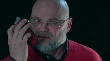 Sinirli, duygusal bir adam, engelliye bağırıyor ve akıllı telefondan konuşuyor.