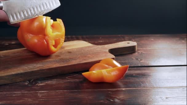 Chef Skär Orange Paprika Skärbräda Köket Ett Gammalt Träbord — Stockvideo
