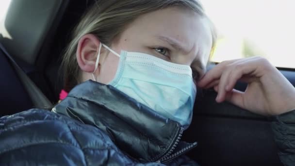 Znudzona Mała Dziewczynka Masce Ustach Jeździ Tylnych Siedzeniach Samochodu Koncepcja — Wideo stockowe