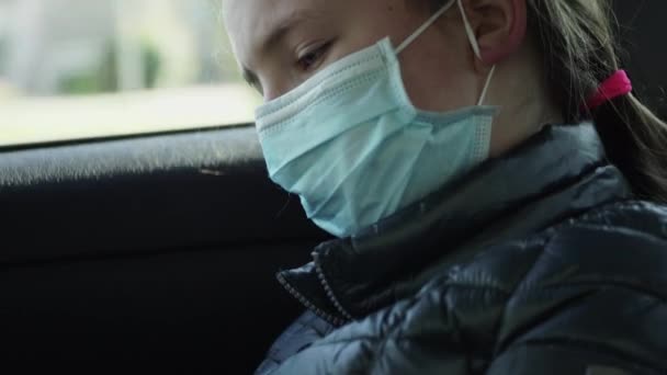 Gelangweilte Kranke Kleine Mädchen Mit Mundschutz Fahren Auf Den Rücksitzen — Stockvideo