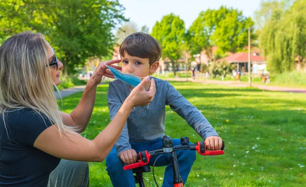 Anne ve çocuk açık havada koronavirüs ve grip salgını sırasında yüz maskesi takıyor. Virüs ve hastalık koruması. Seçici odak