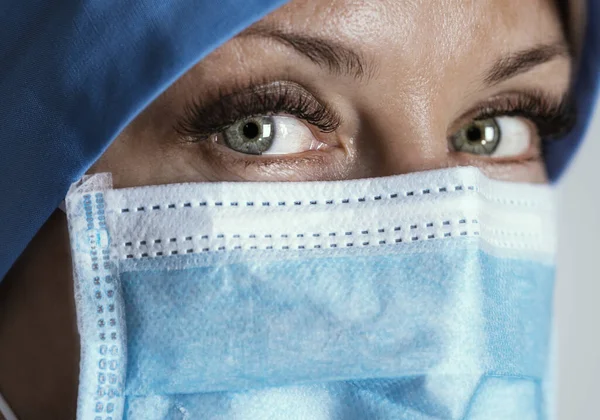 Maskeli yorgun doktor kameraya bakıyor. Kapatın. Seçici odak