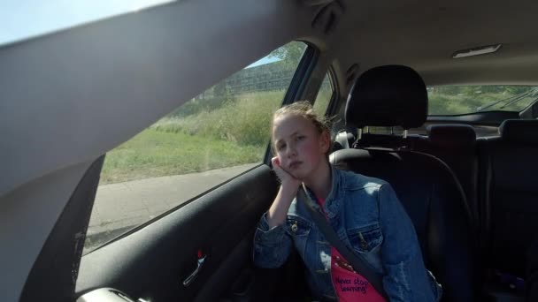 Znudzona Dziewczyna Jedzie Samochodzie Patrzy Przez Okno Dziewczyna Smutną Twarzą — Wideo stockowe