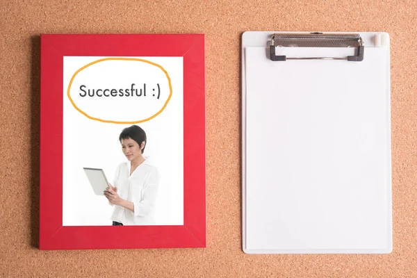 clipboard and photo of business woman in frame on wooden table