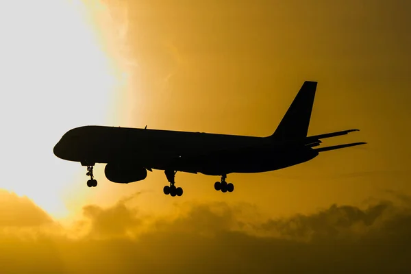 日没時に空を飛ぶ飛行機 — ストック写真