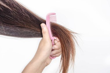 Fırça ve uzun saçlarla birlikte. Güzel görünmek için günlük hazırlık, Uzun Bulaşık Saçlar, Dağınık Saçları Ellerinde Tutmak. Saç Hasarı, Sağlık ve Güzellik Konsepti, kuru saçtan mutsuz.