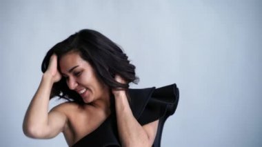 Gri beyaz arka plan aleyhine poz mayo güzel kız. Bakımlı deri. Seksi kıyafetleri .