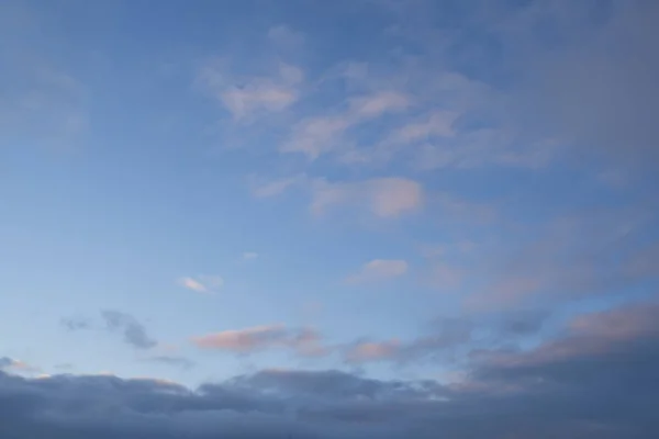 Beautiful evening blue sky at sunset with flaming bright light clouds — ストック写真