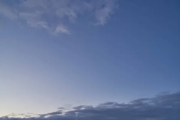 Beautiful evening blue sky at sunset with flaming bright light clouds — ストック写真