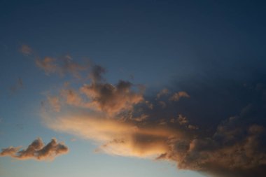 Gün batımında parlayan parlak ışık bulutlarıyla güzel bir akşam masmavi gökyüzü. Sıcak bir yaz akşamı.