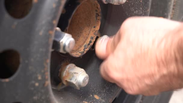 Imagem detalhada de mãos mecânicas com ferramenta trocando pneu do carro, substituição de pneus verão de inverno . — Vídeo de Stock