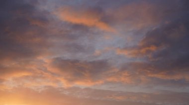Gün batımında parlayan parlak ışık bulutlarıyla güzel bir akşam mavisi gökyüzü. Sıcak bir akşam