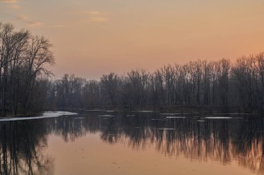 Gölün üstünde şafak. Gün batımında parlayan parlak ışık bulutlarıyla güzel bir akşam masmavi gökyüzü. Sıcak yaz akşamı gün batımında.
