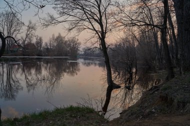 Gölün üstünde şafak. Gün batımında parlayan parlak ışık bulutlarıyla güzel bir akşam masmavi gökyüzü. Sıcak yaz akşamı gün batımında.