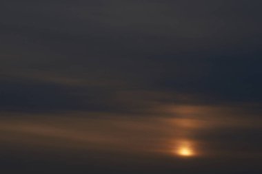 Gün batımında parlayan parlak ışık bulutlarıyla güzel bir akşam mavisi gökyüzü. Sıcak bir akşam. Nisan. Mayıs.