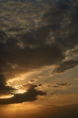 Gün batımında parlayan parlak ışık bulutlarıyla güzel bir akşam mavisi gökyüzü. Sıcak bir akşam. Nisan. Mayıs.