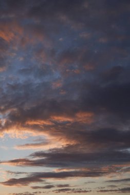 Gün batımında parlayan parlak ışık bulutlarıyla güzel bir akşam mavisi gökyüzü. Sıcak bir akşam. Nisan. Mayıs.