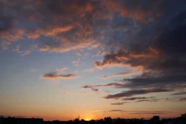 Gün batımında parlayan parlak ışık bulutlarıyla güzel bir akşam mavisi gökyüzü. Sıcak bir akşam. Nisan. Mayıs.