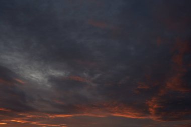 Gün batımında parlayan parlak ışık bulutlarıyla güzel bir akşam mavisi gökyüzü. Sıcak bir akşam. Nisan. Mayıs.