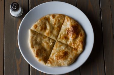 Osetya pasta patates veya koyun eti beyaz tabakta. Ahşap arka plan.