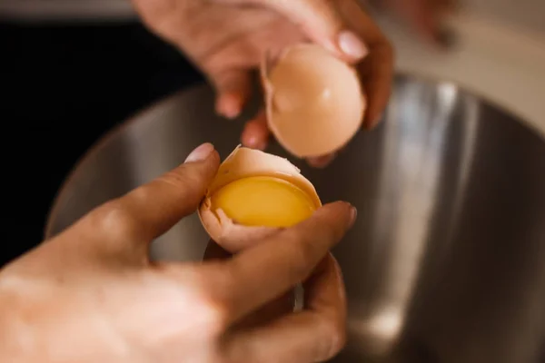 Kézi break egy tojás, és ömlött a tálba. A sárgája ízletes omlett és elválasztja fehérje fontos eleme. A magas fehérjetartalmú étel összetevő. — Stock Fotó