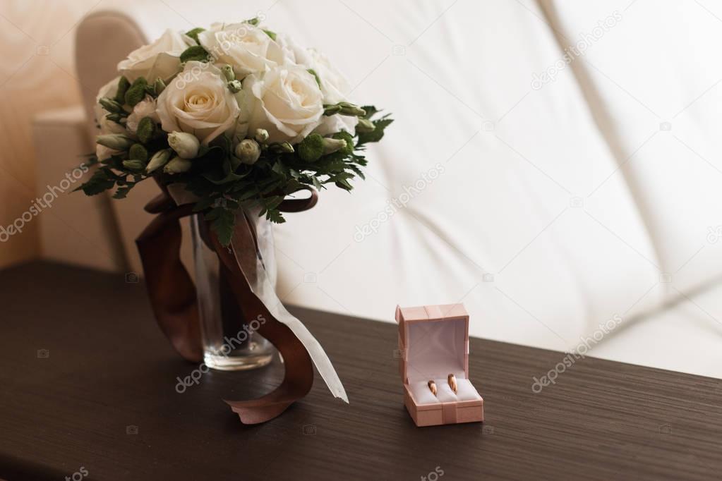 Wedding bouquet of yellow and white roses and blue fresia lying on wooden floor