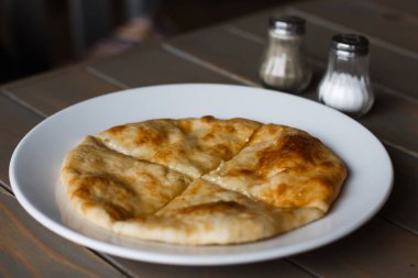 Osetya pasta patates veya koyun eti beyaz tabakta. Ahşap arka plan.