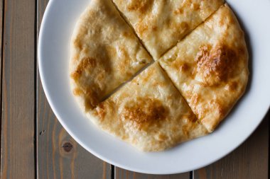 Osetya pasta patates veya koyun eti beyaz tabakta. Ahşap arka plan.