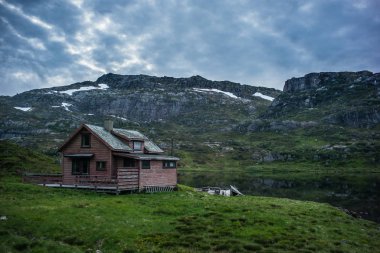 Norveç göl ve dramatik gökyüzü eski ev
