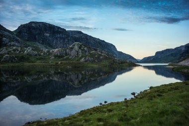 Gün batımında dramatik gökyüzü ile Norveç Gölü