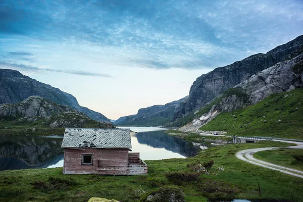 Noruego lago y casa con cielo dramático y vatios tranquilos en su — Foto de Stock